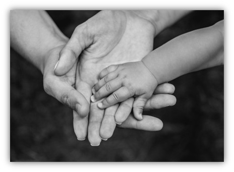 A mom, dad and babies hand on top of each other
